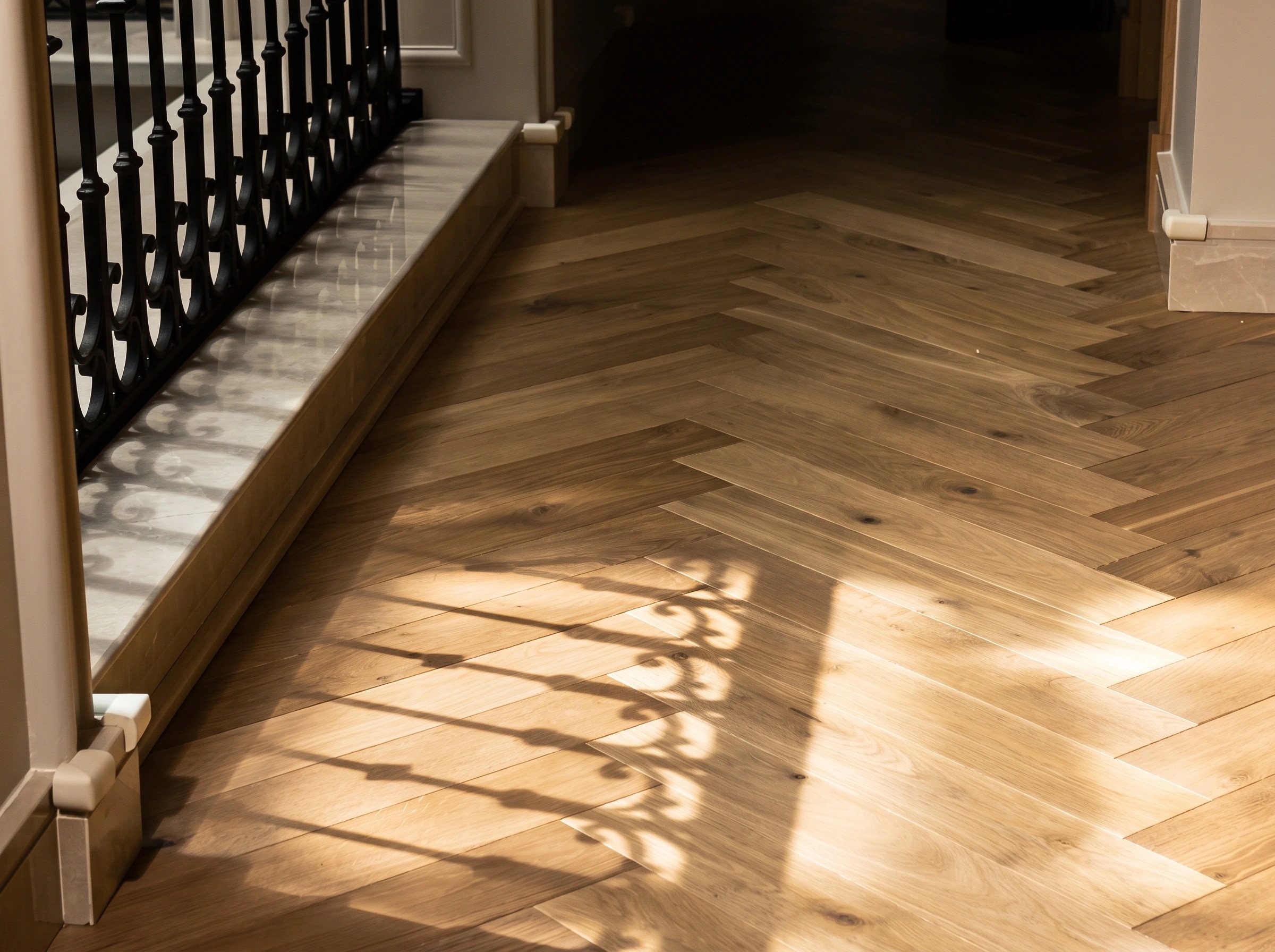 HARO herringbone oak running down a staircase hallway in raking light