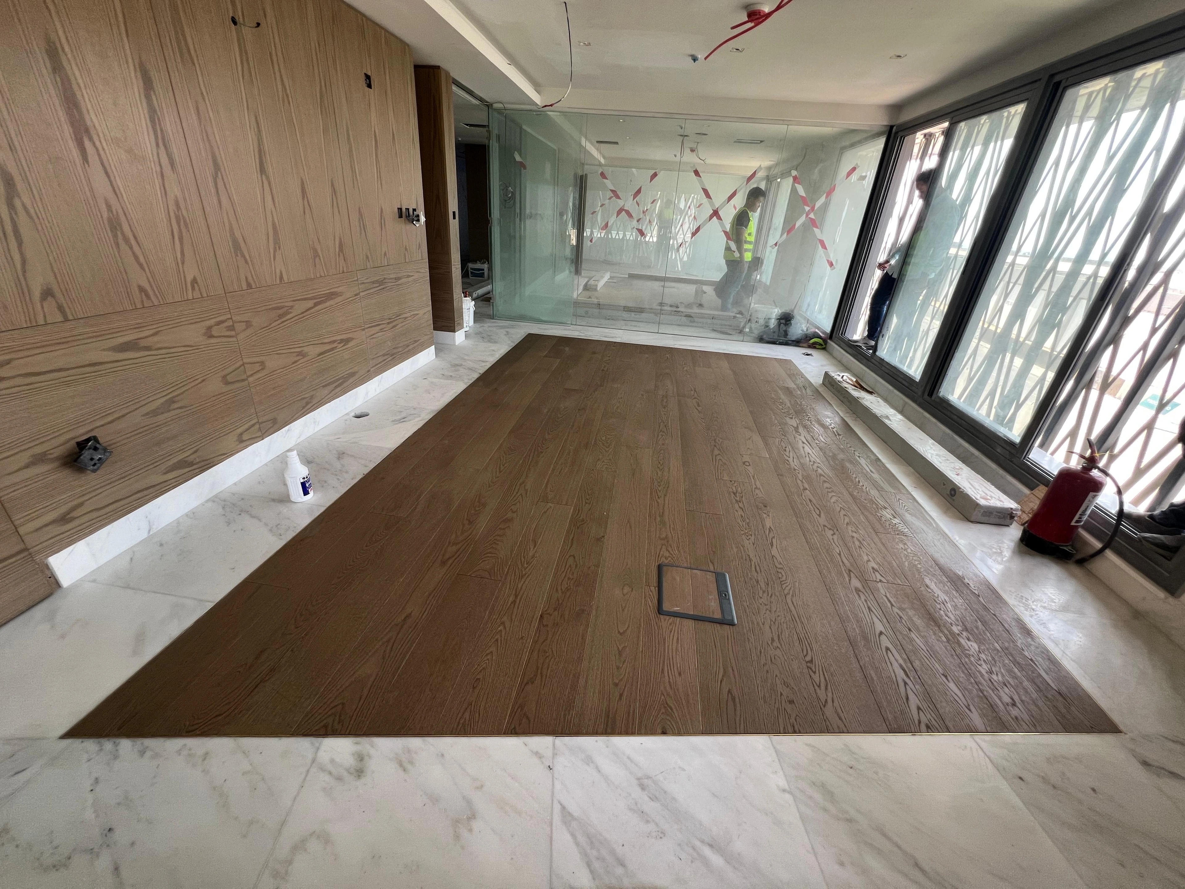 Natural oak flooring aligned with a timber-panelled wall